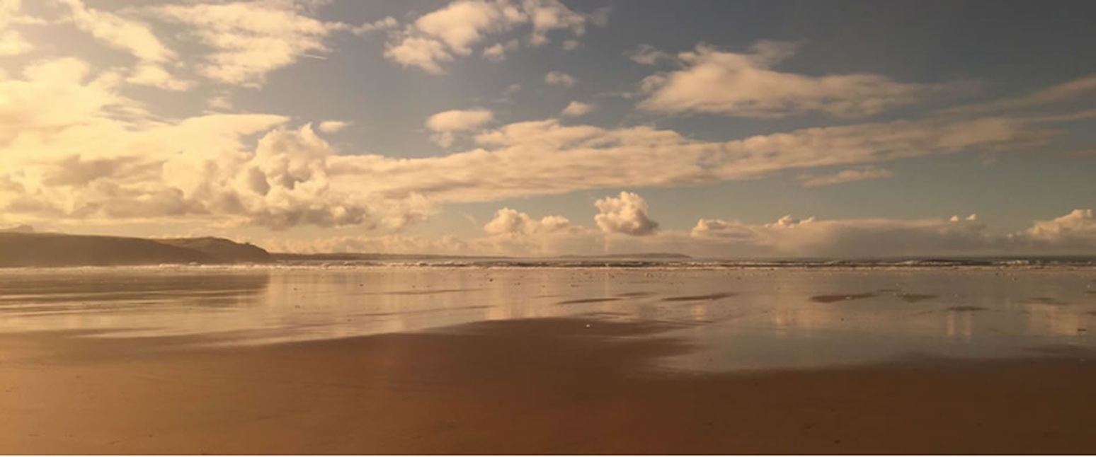 Golden beach beneath dramatic clouds